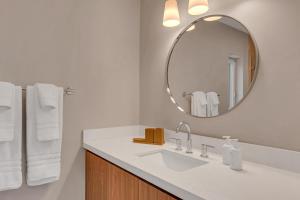 a white bathroom with a sink and a mirror at Peninsula Villa Boat Dock Heated Pool Sunset Point in Islamorada +38 photos