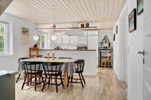 a kitchen and dining room with a table and chairs at 80057-Ulfborg-Rolighedsvej-3 in Ulfborg