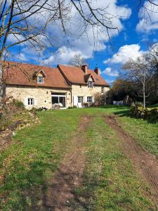 a house with a dirt road in front of it at Maison la Bambine chambre nature in Ozolles