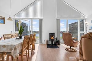 a dining room with a table and chairs and a fireplace at 70774-Ulfborg-Skolegade-15-Lejl-5 in Ulfborg