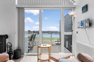 a living room with a balcony with a view of the water at 70774-Ulfborg-Skolegade-15-Lejl-5 in Ulfborg