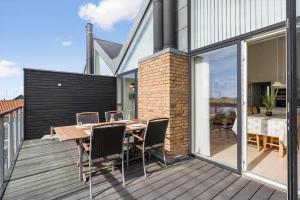 a patio with a table and chairs on a deck at 70774-Ulfborg-Skolegade-15-Lejl-5 in Ulfborg +25 photos