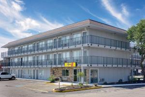 a large white building with a parking lot at Super 8 by Wyndham Florence in Florence