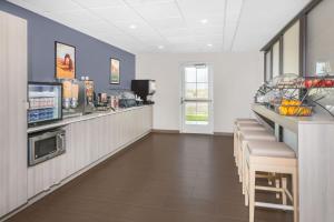 a restaurant with a bar with a counter and chairs at Microtel Inn & Suites by Wyndham Springville in Springville