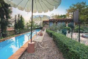 an umbrella and two chairs next to a swimming pool at Moon River Village in Ban Bu Khanun