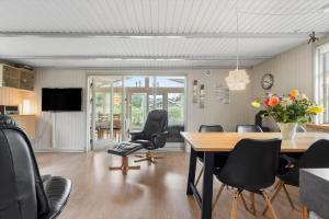 a room with a table and chairs and a television at 30185-Ulfborg-Bellisvej-509 in Ulfborg +16 photos
