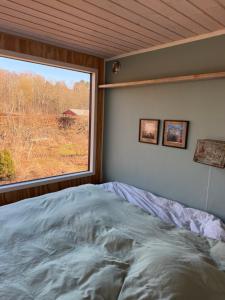 a bed in a room with a large window at Tiny house close to Copenhagen in Nybølle