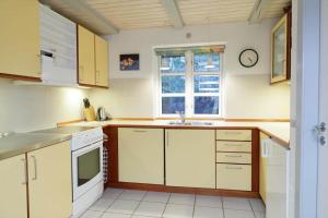a kitchen with white cabinets and a window at 10294-Ulfborg-Gaffelbjergvej-44 in Ulfborg