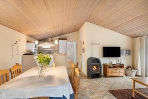 a kitchen and dining room with a table and a fireplace at 30848-Ulfborg-Valmuevej-286 in Ulfborg