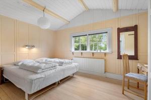 a bedroom with a large bed and a window at 80182-Vemb-Ogelstrupvej-4 in Vemb