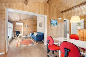 a living room with wooden walls and red chairs at 80182-Vemb-Ogelstrupvej-4 in Vemb