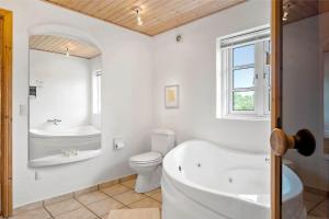 a bathroom with a tub and a toilet and a sink at 20708-Ulfborg-Sortebaervej-6 in Ulfborg +25 photos