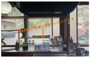 a window in a kitchen with a counter with bottles at 古民家白馬 in Nagano