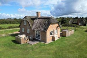 an old house with a thatched roof on a field at 20708-Ulfborg-Sortebaervej-6 in Ulfborg