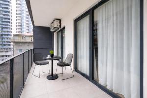 a balcony with two chairs and a table on a balcony at Next White Aparthotel OFFICIAL in Batumi