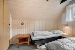 a room with two twin beds and a table at 20220-Ulfborg-Sundhuse-13 in Ulfborg