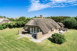 a house with a thatched roof on a field at 20220-Ulfborg-Sundhuse-13 in Ulfborg