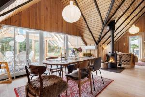 a dining room with a table and chairs and a fireplace at 80179-Vemb-Harpotvej-74 in Vemb +20 photos
