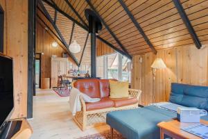 a living room with a leather couch and a table at 80179-Vemb-Harpotvej-74 in Vemb