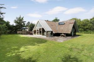a house with a metal roof on a field at 80179-Vemb-Harpotvej-74 in Vemb