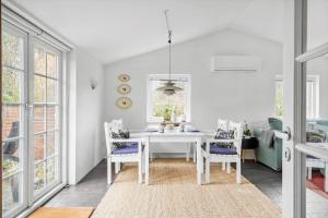 a white dining room with a white table and chairs at 10808-Ulfborg-Vester-Mosevej-84 in Ulfborg
