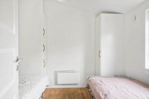 a white bedroom with two beds and a radiator at 10808-Ulfborg-Vester-Mosevej-84 in Ulfborg