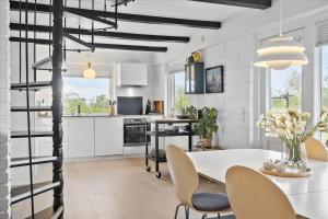 a kitchen and dining room with a white table and chairs at 20041-Ulfborg-Knakvej-10 in Ulfborg +16 photos