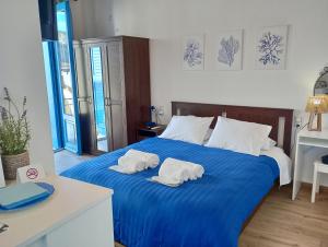a bedroom with two towels on a blue bed at Rooms of Nectar in Poros