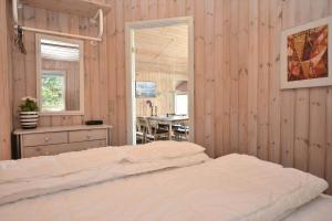 a bedroom with a bed and a table and a window at 30872-Ulfborg-Bellisvej-514 in Ulfborg