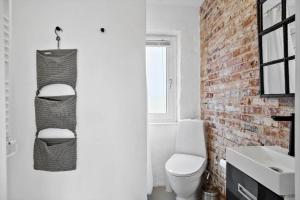 a bathroom with a white toilet and a brick wall at 70181-Ulfborg-Enghavevej-2 in Ulfborg +31 photos