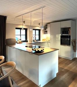 a kitchen with white cabinets and a large island at 10735-Ulfborg-Graevlingevej-11 in Ulfborg