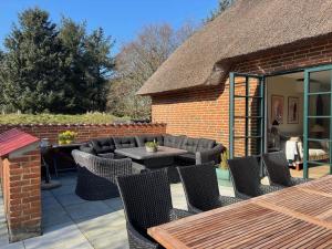 a patio with chairs and tables and a brick building at 10735-Ulfborg-Graevlingevej-11 in Ulfborg