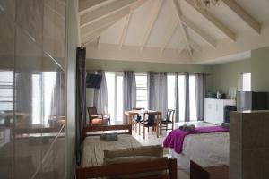 a bedroom with a bed and a dining room at Rothman's Sea View in Pacaltsdorp