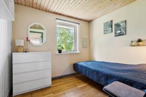 a bedroom with a bed and a dresser and a window at 30789-Ulfborg-Akelejevej-276 in Ulfborg