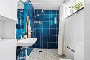 a blue tiled bathroom with a sink and a shower at 30789-Ulfborg-Akelejevej-276 in Ulfborg +29 photos