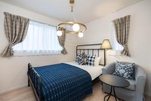 a bedroom with a bed and a chair and a chandelier at Villa Gotemba Holidays in Gotemba +64 photos