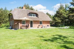 a small brick house with a thatched roof at 10718-Ulfborg-Baekbyvej-117 in Ulfborg