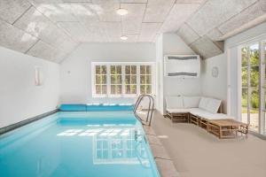 a swimming pool in a room with a couch and a table at 10611-Ulfborg-Gaffelbjergvej-6 in Ulfborg
