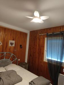 a bedroom with a ceiling fan and a window at La Céret'nitude in Céret
