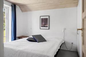 a bedroom with a bed with a black and white pillow at 10611-Ulfborg-Gaffelbjergvej-6 in Ulfborg +16 photos