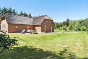 a brick barn with a table and chairs in a yard at 10611-Ulfborg-Gaffelbjergvej-6 in Ulfborg