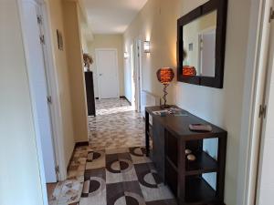 a hallway with a desk and a mirror on a wall at Torre Plaza 5 in Boiro