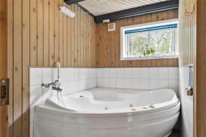 a white tub in a bathroom with a window at 10755-Ulfborg-Kjaergaardvej-20 in Ulfborg
