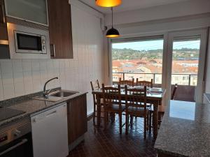 a kitchen with a table and a dining room with a view at Torre Plaza 5 in Boiro