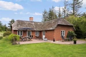 a brick house with a roof with a patio at 10755-Ulfborg-Kjaergaardvej-20 in Ulfborg