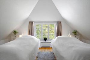 two beds in a attic room with a window at 10833-Ulfborg-Graemvej-19 in Ulfborg