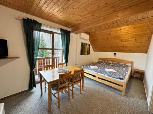a bedroom with a bed and a table and chairs at Chata Boubín in Kubova Huť
