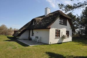 a house with a thatched roof on a field at 20038-Ulfborg-Knakvej-8 in Ulfborg