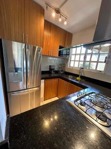 a kitchen with a stainless steel refrigerator and a stove at Casita Océano in La Paz