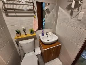 a small bathroom with a toilet and a sink at Jade's Place Condo in Bacolod +29 photos